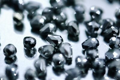 Black diamonds are reflecting light on a shiny surface.