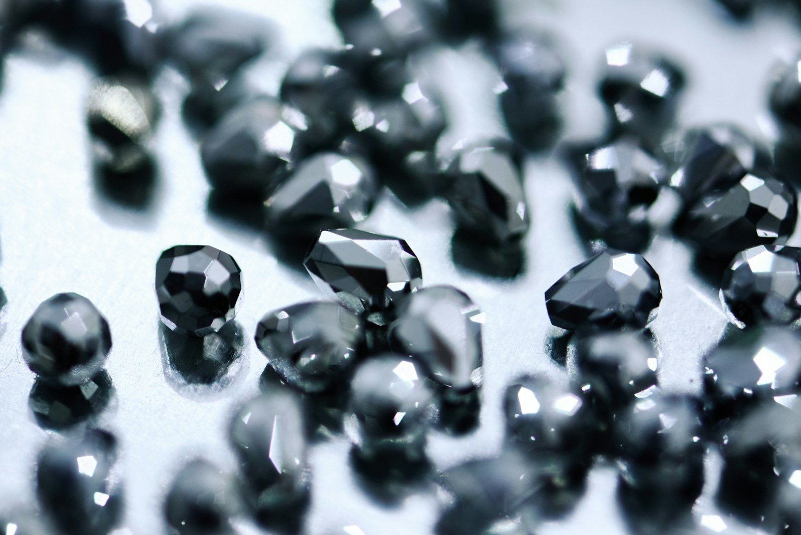 Black diamonds are reflecting light on a shiny surface.