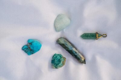 An assortment of healing crystals displayed on white fabric, representing alternative medicine and spiritual themes.