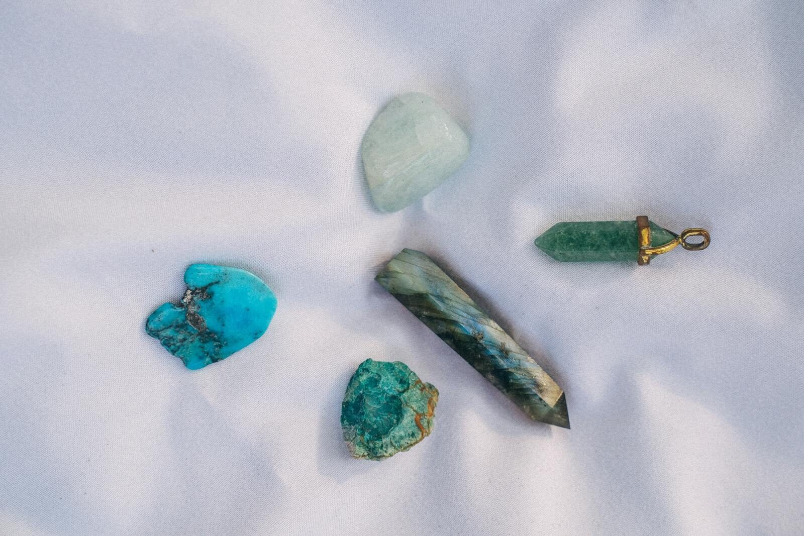 An assortment of healing crystals displayed on white fabric, representing alternative medicine and spiritual themes.