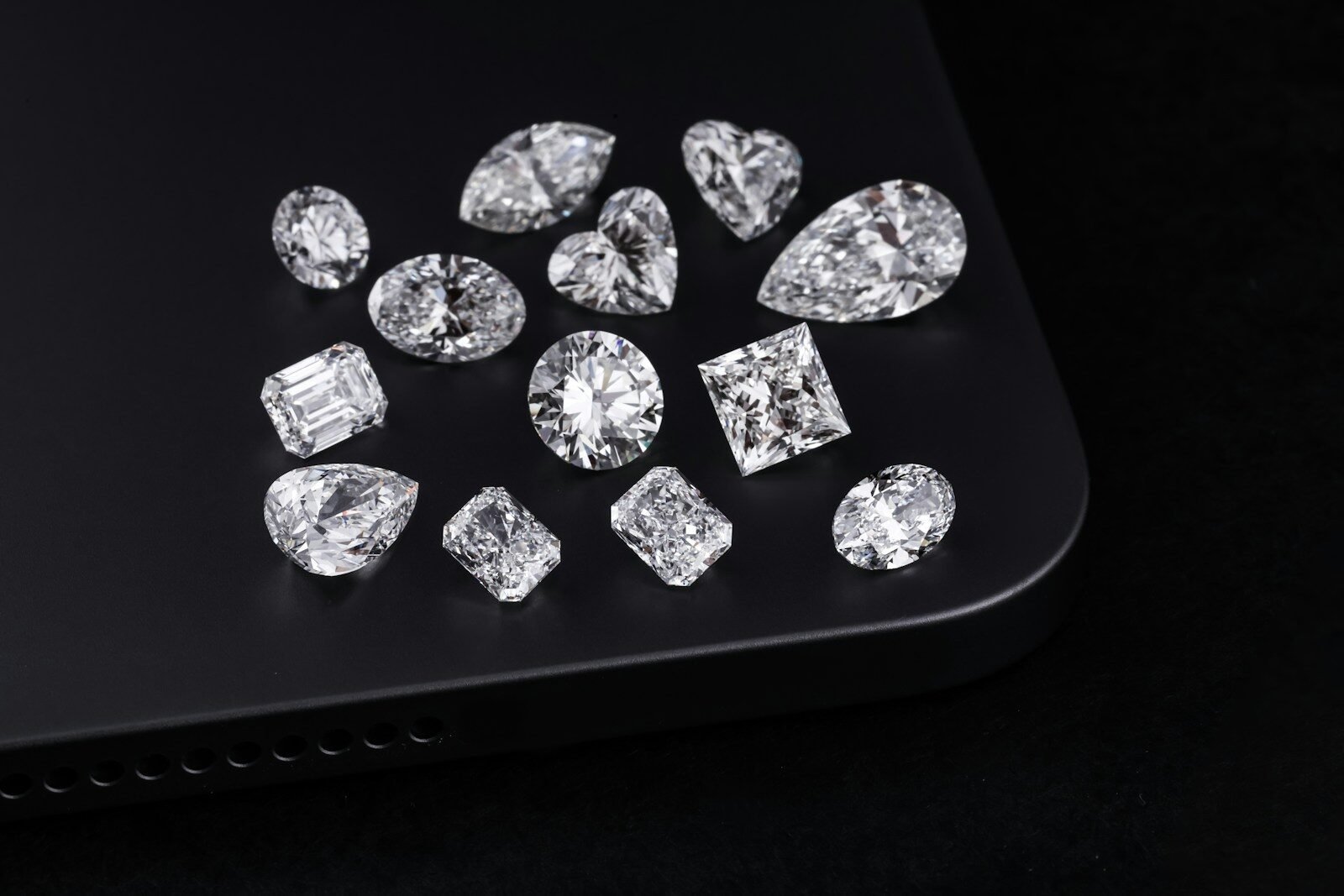 Diamonds of various shapes are on a black surface.