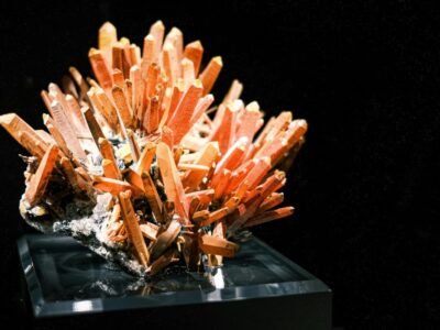 Cluster of orange quartz crystals on black background